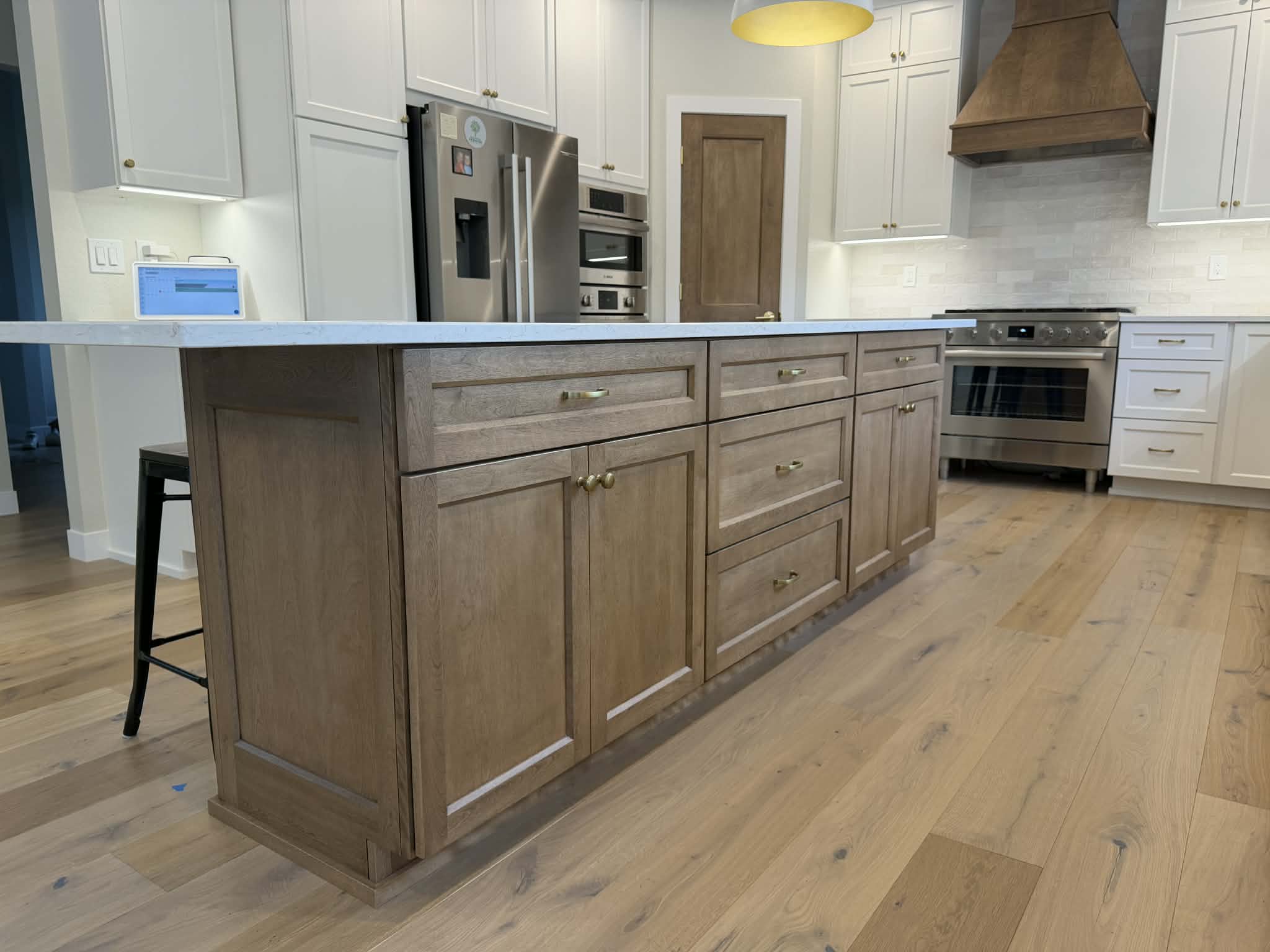 Custom stained kitchen island with quartz countertop and brass hardware