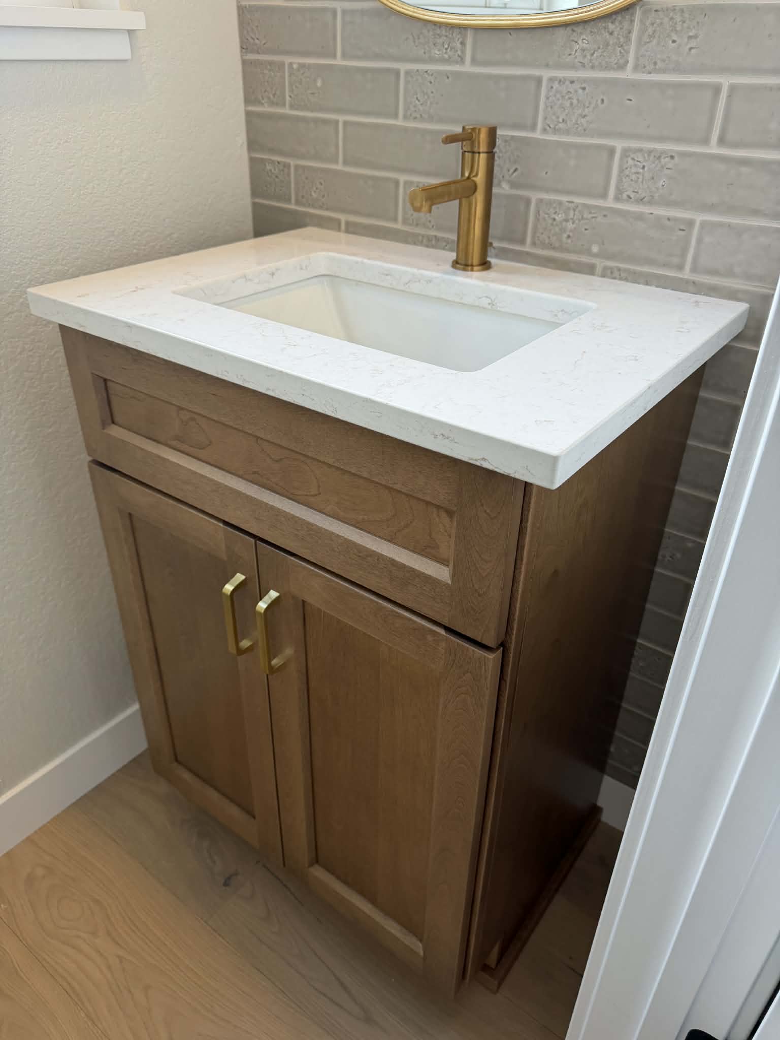 Custom stained bathroom vanity with quartz top and brass fixtures